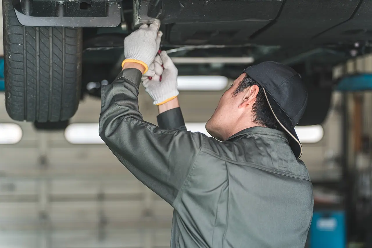 車の下回りを点検・整備している自動車整備士