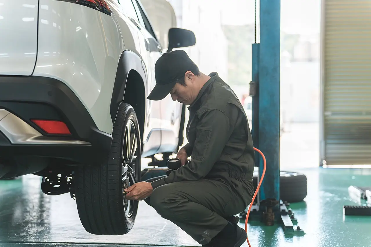 整備工場で車のタイヤをメンテナンスする様子